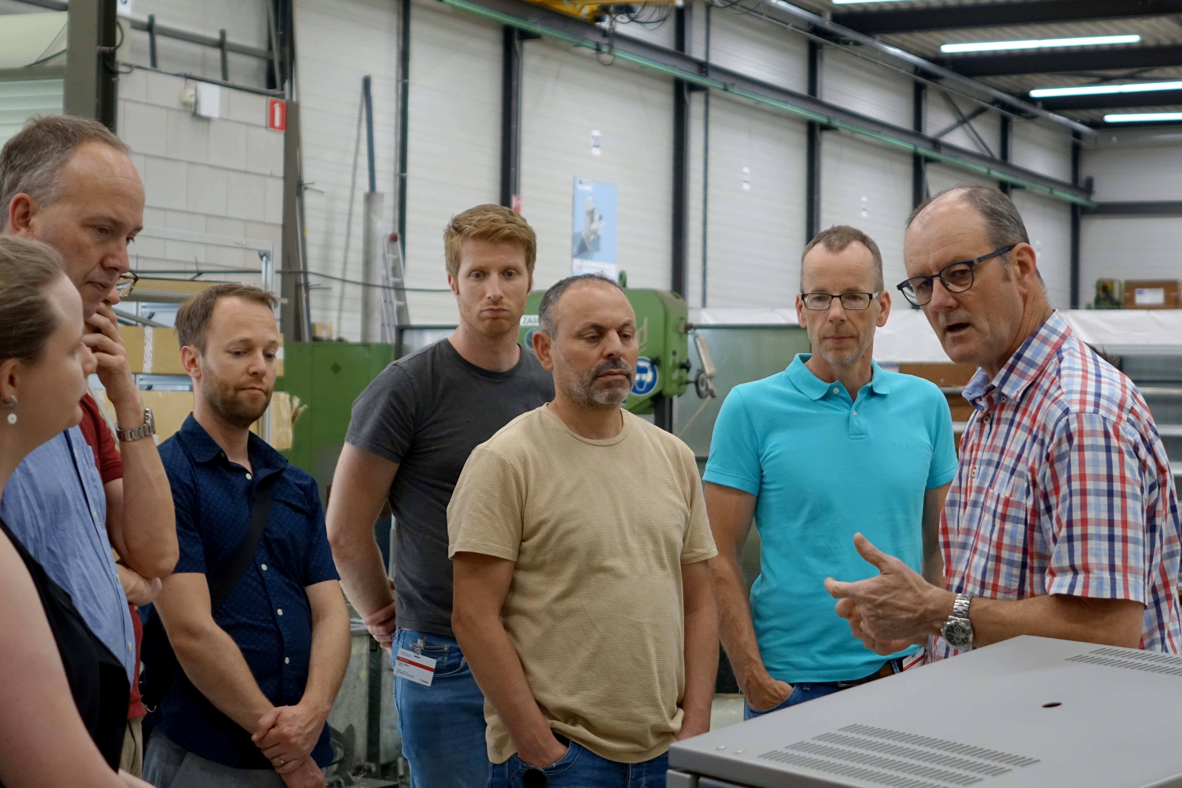 Canon Production Printing op bezoek bij Manders Automation. John Thijssen geeft de groep uitleg over sealmachines.